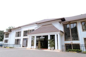 een wit gebouw met een zwart dak bij West Wood Hotel in Nairobi