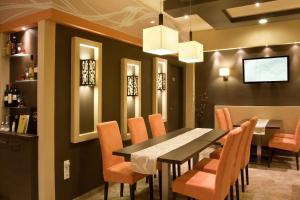 a dining room with a table and chairs at Alfa Hotel in Győr