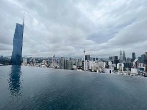 a view of the city from the infinity pool of a skyscraper at Lucentia Residence BBCC Lalaport at Kuala Lumpur By Luxe Home in Kuala Lumpur