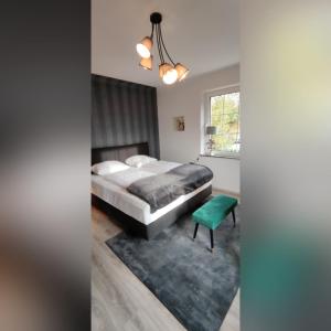 1 dormitorio con cama y taburete verde en Ferienvilla, en Eppelborn