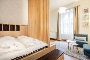 a bedroom with a large bed and a blue chair at GoldenFeet Studio in Budapest