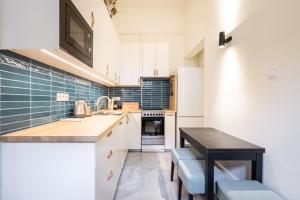 a kitchen with white cabinets and a black table at GoldenFeet Studio in Budapest