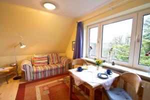 a living room with a table and a chair and a window at Oome Tilles Hüs in Norddorf