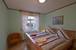 a bedroom with a bed with a window at Oome Tilles Hüs in Norddorf