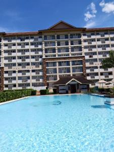 a large swimming pool in front of a hotel at One Oasis Apartment CDO in Cagayan de Oro