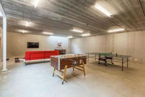 Habitación con 2 mesas de ping pong y sofá rojo. en Coccinelle, en Biggekerke