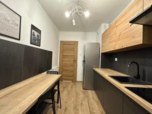 a kitchen with a wooden counter top and a refrigerator at Pruszkowskie mieszkanko in Pruszków