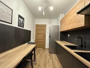 eine Küche mit einer Holzarbeitsplatte und einem Kühlschrank in der Unterkunft Pruszkowskie mieszkanko in Pruszków
