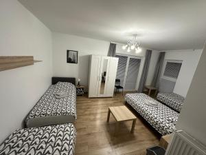 a room with two beds and a table in it at Pruszkowskie mieszkanko in Pruszków