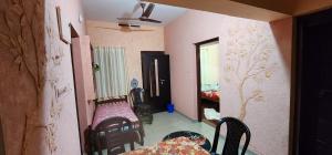 una habitación con mesa y sillas y un dormitorio en JJ's Holiday Home en Thanniyam