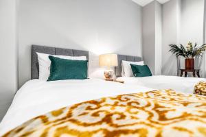 a bedroom with two beds with white and green pillows at Central Castle House in Norwich