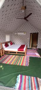 拉姆納格爾的住宿－Corbett Nature Retreat，一间卧室配有床和色彩缤纷的地毯