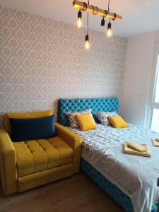 ein Schlafzimmer mit einem Bett und einem gelben Sofa in der Unterkunft Studio Lena 1 in Divčibare