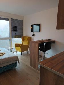 ein Wohnzimmer mit einem Schreibtisch und einem gelben Stuhl in der Unterkunft Studio Lena 1 in Divčibare