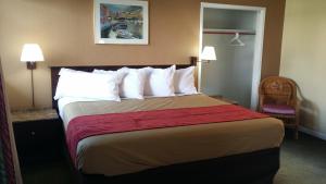 a hotel room with a large bed with white pillows at The Palms On Ocean in Pompano Beach