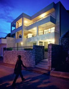 Una mujer caminando delante de una casa por la noche en Villa Katarina Dubrovnik, en Dubrovnik