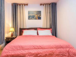 a bedroom with a bed with a red comforter at Onvara Place in Phra Nakhon Si Ayutthaya