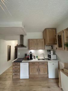 - une cuisine avec des placards en bois et des appareils blancs dans l'établissement Appartement balinais Lumineux et calme, à Avignon 5 autres photos