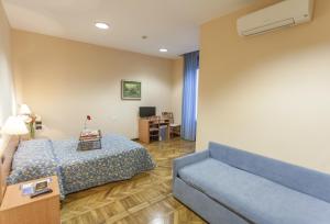 サルソマッジョーレ・テルメにあるHotel Principeのベッドとソファ付きのホテルルーム