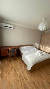 a bedroom with a bed and a desk and a chair at На Тархана in Astana