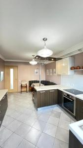 a large kitchen with a large island in a room at На Тархана in Astana