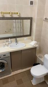 a bathroom with a sink and a washing machine at На Тархана in Astana