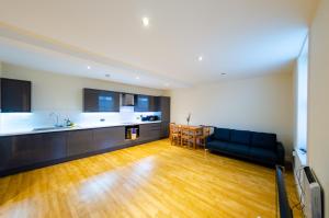 a living room with a black couch and a kitchen at Large Apartment 2 Bedrooms - 2 Bathrooms in Ipswich