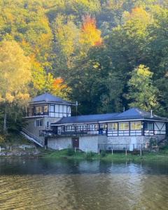 a large house sitting on the side of a lake at Słoneczny dom nad Jeziorem Bystrzyckim in Zagórze Śląskie