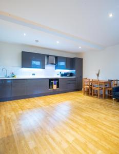 a large kitchen and dining room with a wooden floor at Large Apartment 2 Bedrooms - 2 Bathrooms in Ipswich