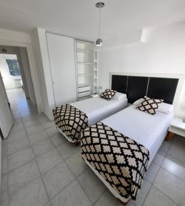 a bedroom with two beds and a couch at Bariloche Modern Apartment Belgrano in San Carlos de Bariloche
