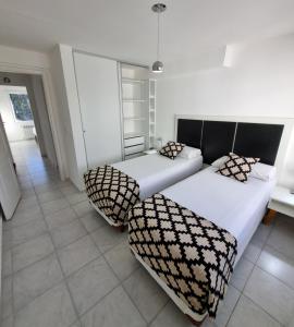 une chambre avec deux lits et un canapé dans l'établissement Bariloche Modern Apartment Belgrano, à San Carlos de Bariloche