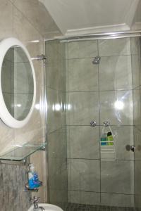 a bathroom with a shower with a mirror and a sink at South Peninsula Beach Apartment in Cape Town +40 photos