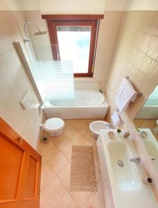 a bathroom with a tub and a toilet and a sink at Casa Relax con Terrazza Panoramica in Fiumicino