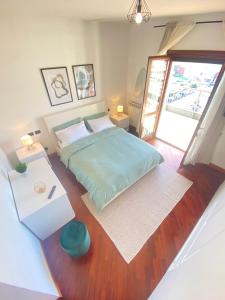 a bedroom with a large bed and a wooden floor at Casa Relax con Terrazza Panoramica in Fiumicino