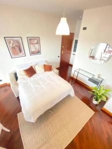 a bedroom with a large white bed and a rug at Casa Relax con Terrazza Panoramica in Fiumicino