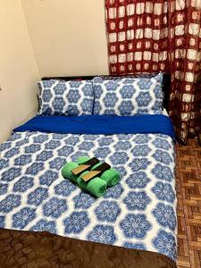 a bed with a blue and white comforter and pillows at May’s Home Away from Home in Cebu City