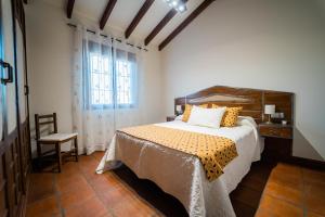 - une chambre avec un lit, une chaise et une fenêtre dans l'établissement Casa Rural Los Menhires, à Malaga