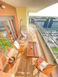 Un balcón con mesas y sillas en un edificio en Casa Relax con Terrazza Panoramica, en Fiumicino