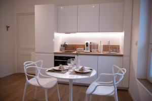 a white kitchen with a white table and chairs at au42dotBzh in Saint-Brieuc