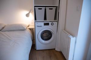 a washer and dryer in a bedroom next to a bed at au42dotBzh in Saint-Brieuc