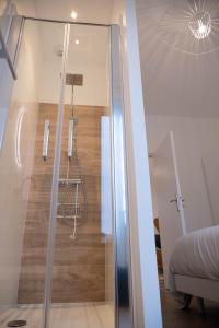 a glass shower in a room with a wooden floor at au42dotBzh in Saint-Brieuc
