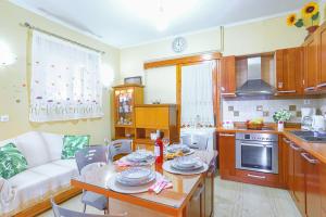 eine Küche und ein Wohnzimmer mit einem Tisch und einem Sofa in der Unterkunft Agathi House in Gaios