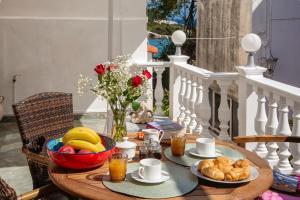 una mesa de madera con productos de desayuno en el balcón en Xenia House, en Gáios