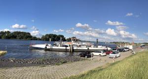 a boat is docked at a dock on a river at Ferienwohnung "elbRetreat" in Seevetal-Over an der Elbe - Stilvoll wohnen auf Zeit in Seevetal