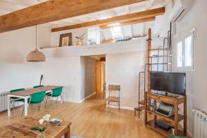 a living room with a dining table and a tv at Atico vistas Estafeta,centro historico in Pamplona