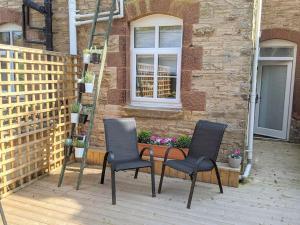 two chairs and a table on a patio at Industrial Cosy Cottage – Gateway to the Lakes in Newbiggin