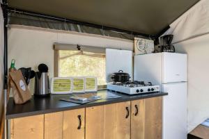 a kitchen in an rv with a stove and refrigerator at Easyatent Safari tent Comfort Bijela Uvala in Poreč