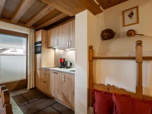 eine Küche in einer Hütte mit Holzschränken und einem Fenster in der Unterkunft Landhaus Elfi in Söll