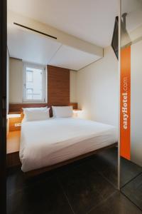 a bedroom with a large white bed with a window at easyHotel Berlin Hackescher Markt in Berlin
