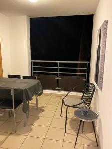 ein Esszimmer mit einem Tisch und Stühlen sowie einem Balkon in der Unterkunft Le Margoze - T2 Boucan Canot in Saint-Gilles-les-Bains